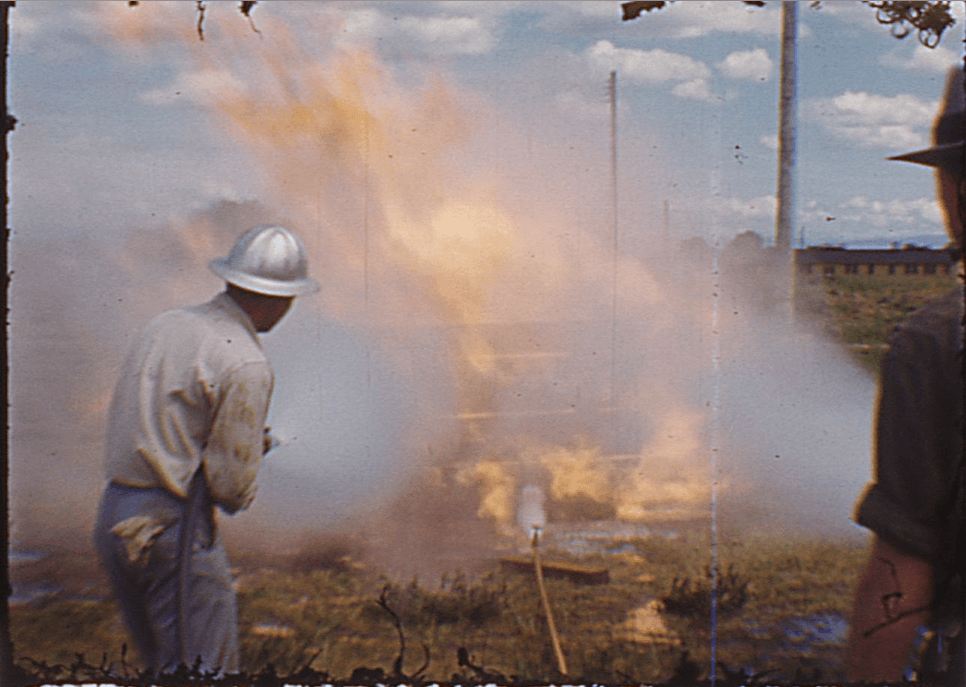 A fire fighter in white dousing the flames