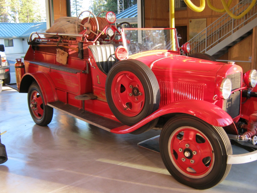 A small vintage fire vehicle parked inside a building