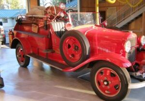 A small vintage fire vehicle parked inside a building